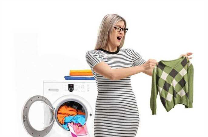 Woman dissatisfied with shrunken sweater after machine drying.