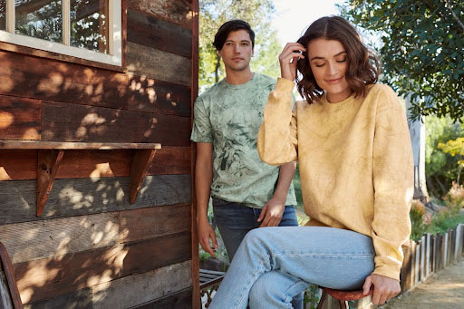 A man and woman wearing the Comfort Colors Color Blast Collection, including the 1745 t-shirt in “Fern” and the 1545CC crewneck sweatshirt in “Citrine”. 
