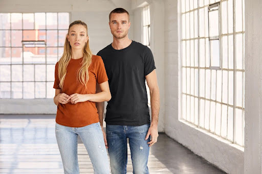 Man and woman wearing the Bella+Canvas 3001C unisex tee in the popular colors, “Autumn” and “Dark Gray”.