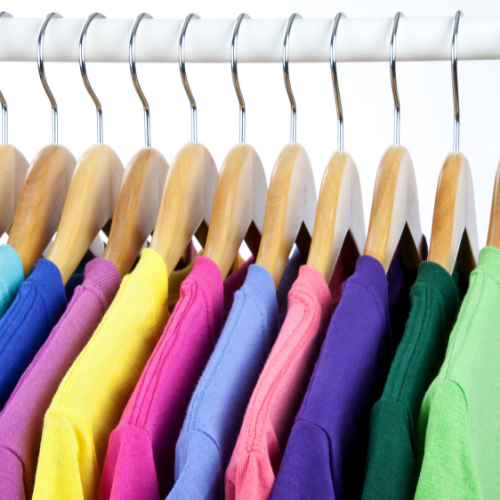 Bright color shirts hanging on a rack.