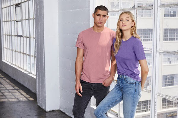 Man and woman modeling the Bella+Canvas 3001C Unisex Jersey Short-Sleeve T-Shirt in the colors heather orchid and heather lapis