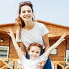 Red headed mom and child outside cabin embracing while wearing white t shirts