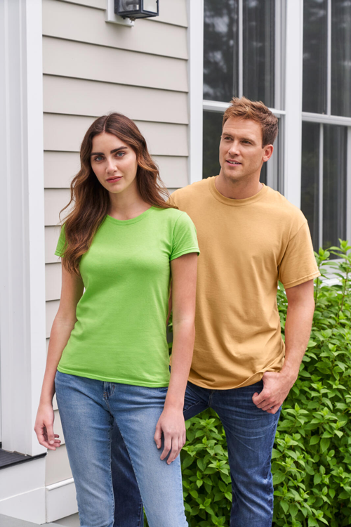 Woman modeling the Gildan G500L women’s t-shirt in “Lime” and a man modeling the G500 unisex tee in “Old Gold”.