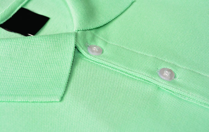 The collar of a mint green pique polo shirt.