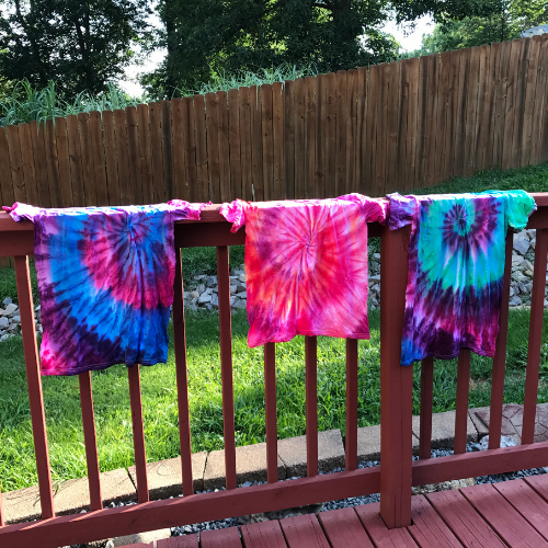 Freshly tie-dyed t-shirts being submerged in water to rinse.
