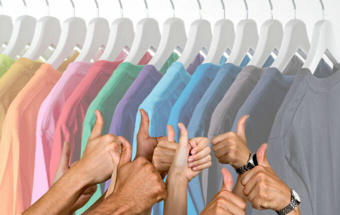 Vibrant shirts neatly hanging on a clothes rack, away from direct sunlight – the best way to store your clothes to prevent fading.