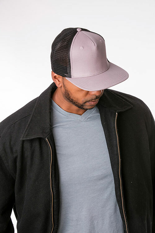  A man facing forward wearing the Big Accessories BX025 Surfer Trucker Cap in “gray/black” with his head tipped down. 