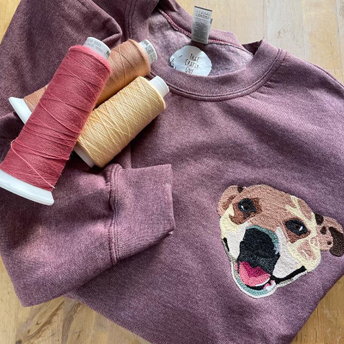 Purple sweatshirt with dog face embroidered on front