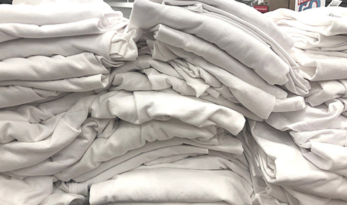 Big pile of folded white t-shirts