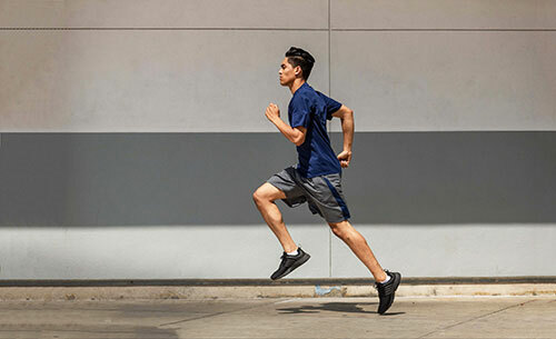 Man running while wearing the A4 N3142 moisture-wicking t-shirt in navy from ShirtSpace.