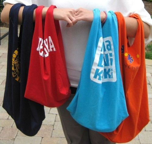 Woman holding 4 tote bags made out of t-shirts