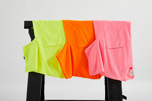 Three Hanes W110 tees in safety colors, hanging over a carpenter’s horse.  