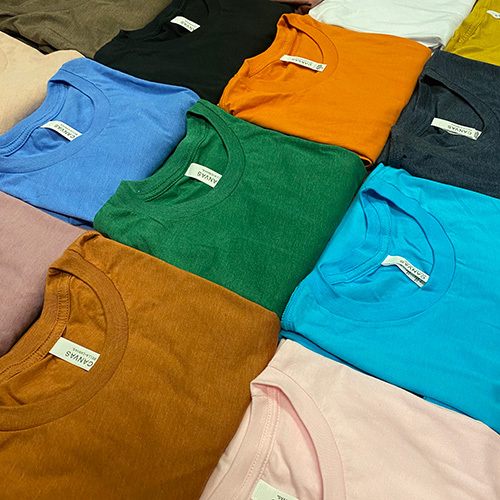 Many colors of the Bella+Canvas 3001CVC Unisex Heather CVC T-Shirts and Bella+Canvas 3001C Unisex Jersey T-Shirts, folded and laid out flat in a checkerboard pattern. 