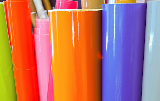 Colorful rolls of heat transfer vinyl, or HTV, that is used to decorate t-shirts.